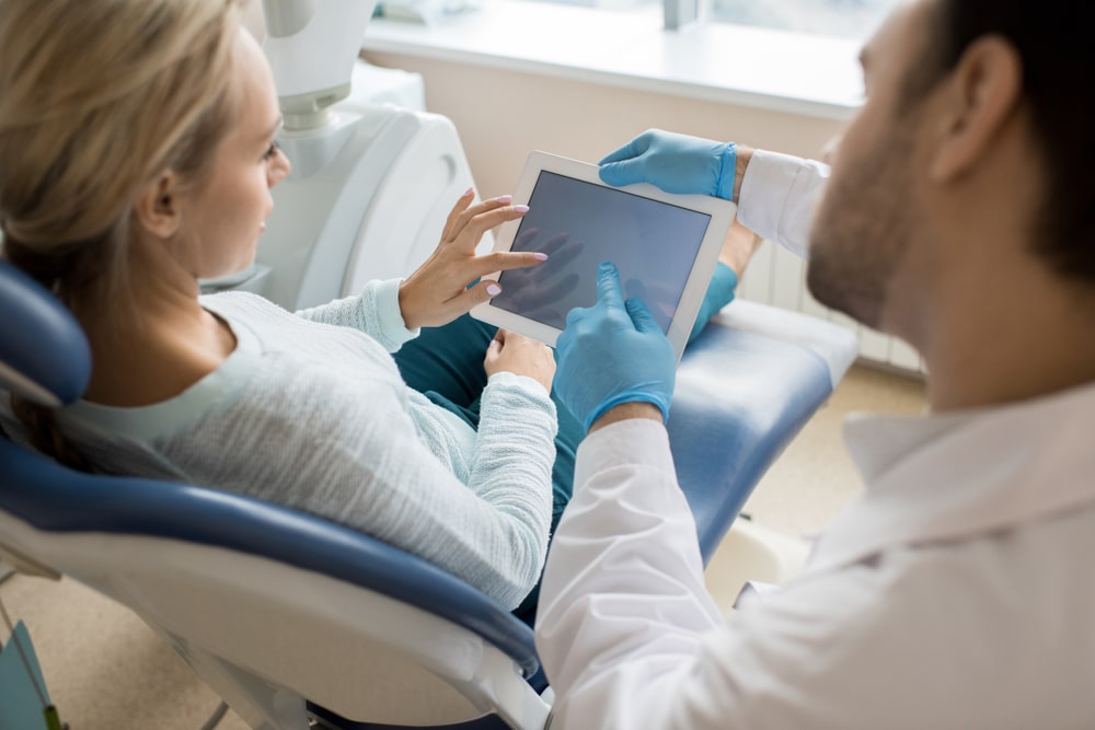 dentist using tablet to talk to patient